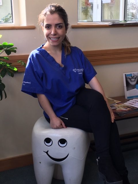 West Country Dental Care dentist sitting on tooth-shaped seat in dental reception