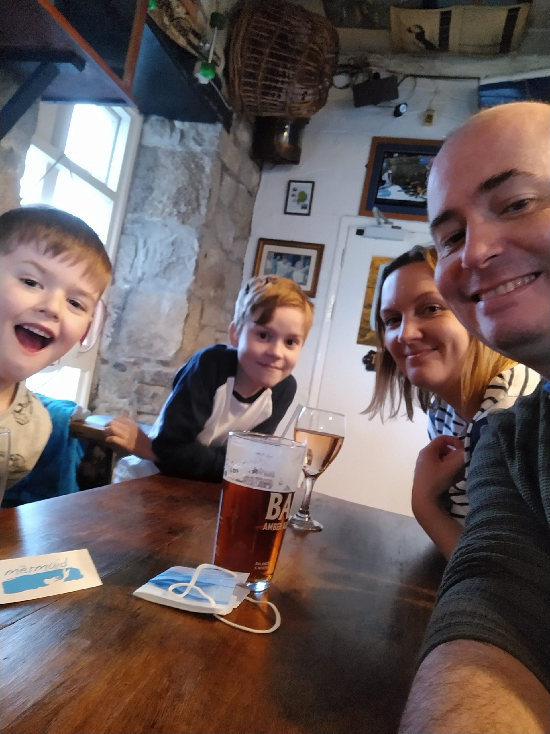 Two adults and two children at pub table indoors