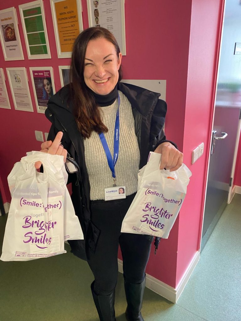lady smiling holding oral health packs