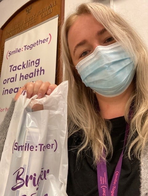 masked woman holding oral health pack