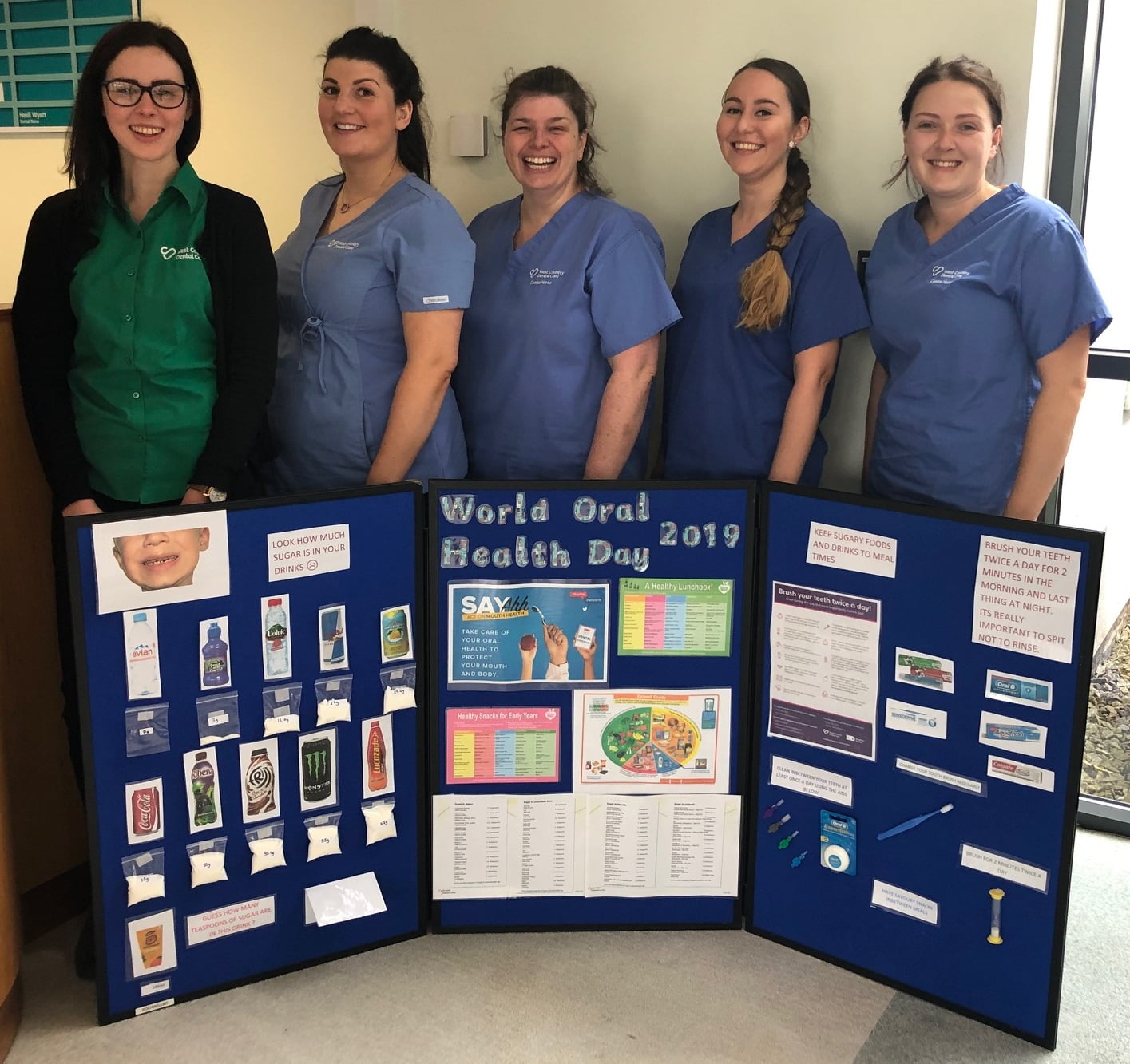West Country Dental Care team standing in reception in Truro with World Oral Health Day 2019 informative display boards