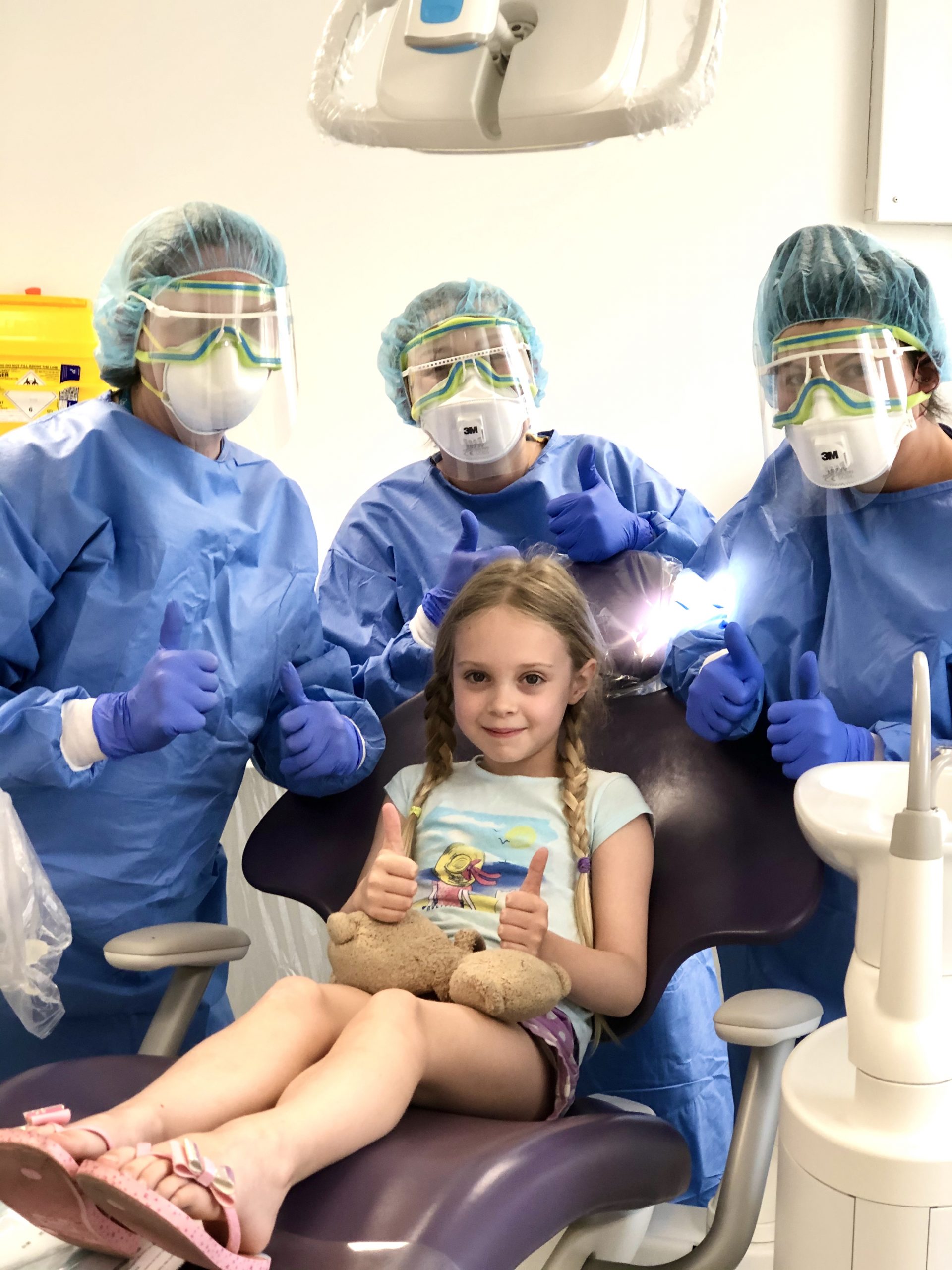 Young patient treated at urgent dental care hub with team in PPE