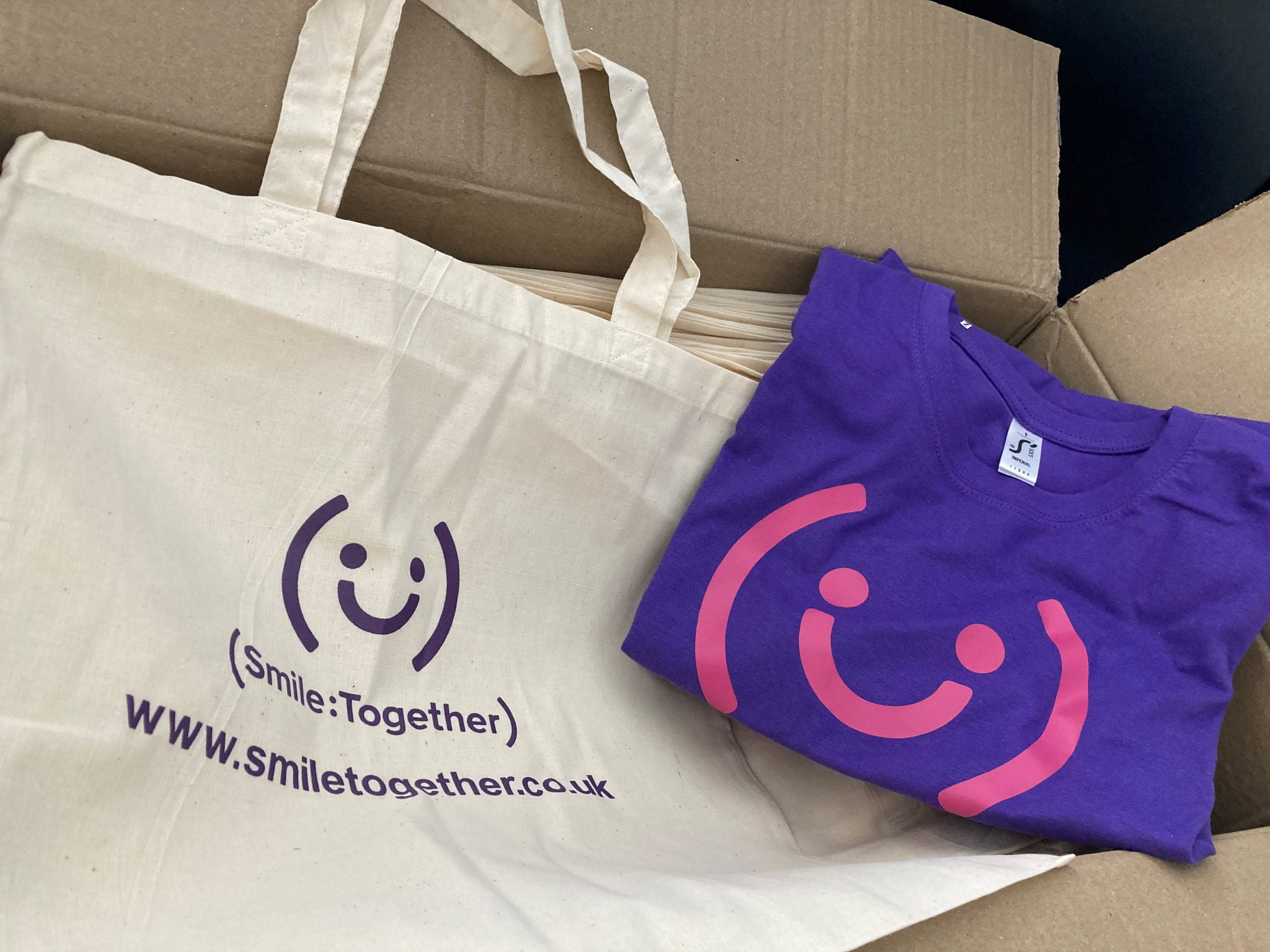 Smile Together branded T-shirts and tote bags