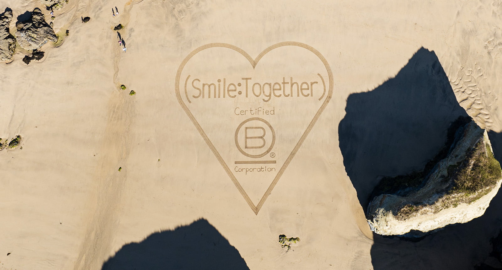 Smile Together b Corp Certified in a heart drawn on the sand